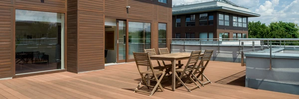 Terrasse en bois moderne avec salon de jardin pliable, situ&eacute;e sur le toit d'un immeuble contemporain
