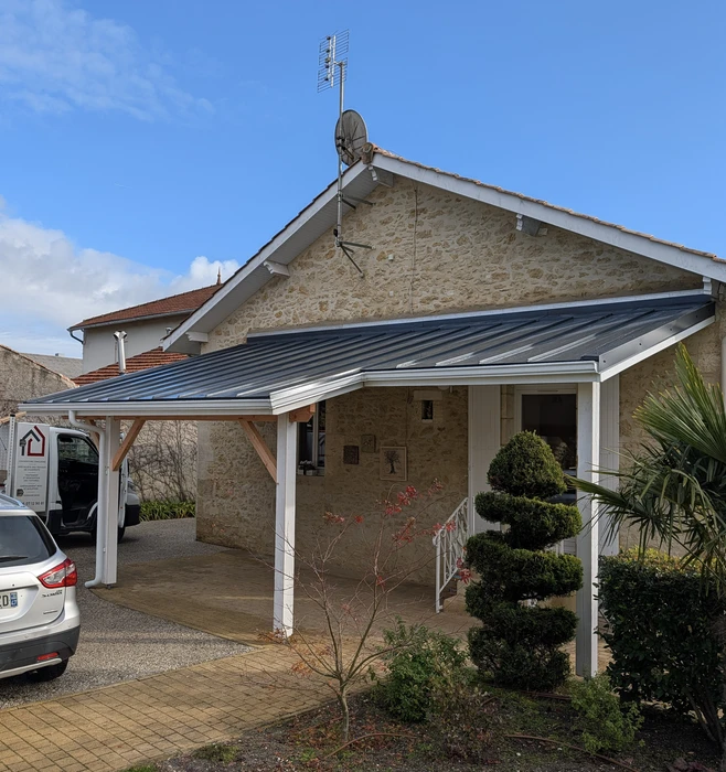 Façade extérieure de bâtiment en cours de rénovation avec bardage bois naturel vertical moderne contrastant avec ancienne section en bois peint gris-bleu vieilli