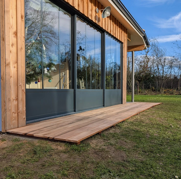 Construction d'une extension en bois avec charpente apparente et toiture en pente