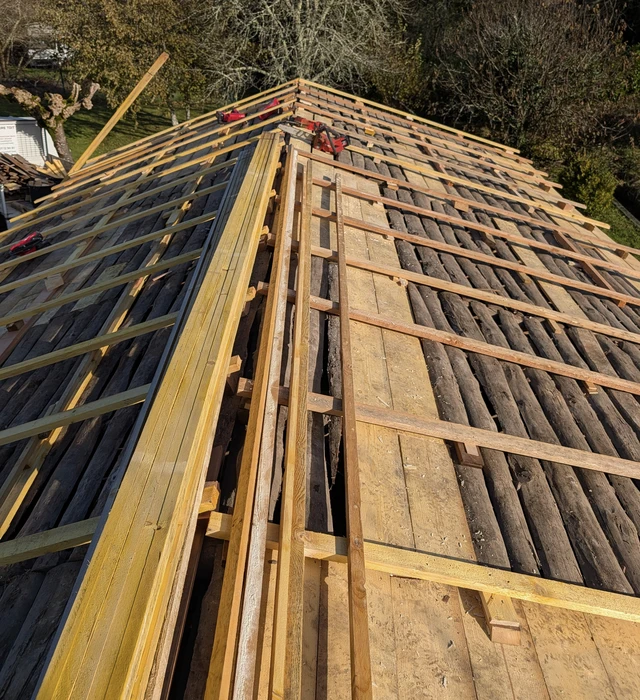 Extension moderne en ossature bois avec bardage vertical, grande baie vitrée coulissante et terrasse en lames de bois