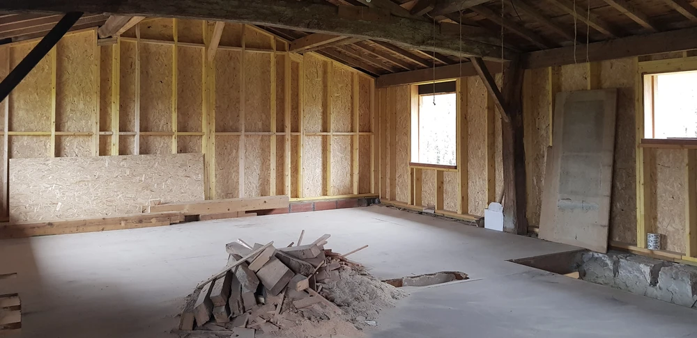 Chantier de construction intérieure en cours, combles aménagés avec charpente bois apparente