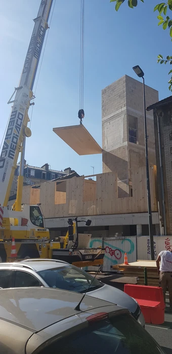 Bâtiment moderne en bois avec bardage vertical, toit à deux pans en tuiles terre cuite