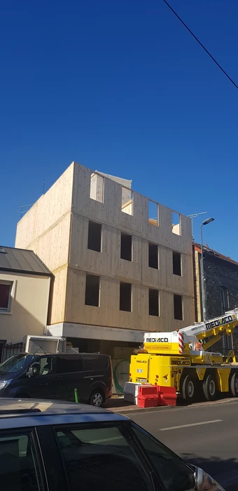 Bâtiment moderne en bois avec bardage vertical, toit à deux pans en tuiles terre cuite