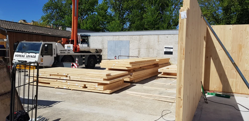 Bâtiment moderne en bois avec bardage vertical, toit à deux pans en tuiles terre cuite