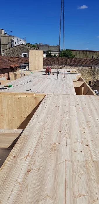 Bâtiment moderne en bois avec bardage vertical, toit à deux pans en tuiles terre cuite