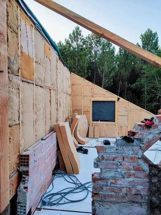 Bâtiment moderne en bois avec bardage vertical, toit à deux pans en tuiles terre cuite