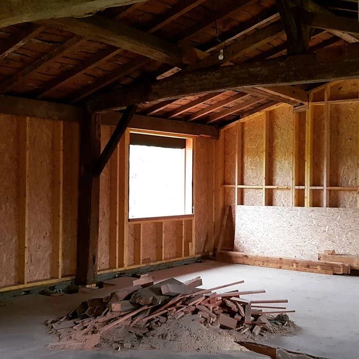 Bâtiment moderne en bois avec bardage vertical, toit à deux pans en tuiles terre cuite