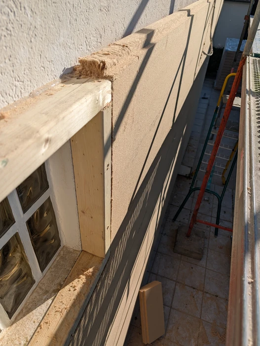 Atelier de menuiserie intérieur avec ouvrier travaillant sur structure bois
