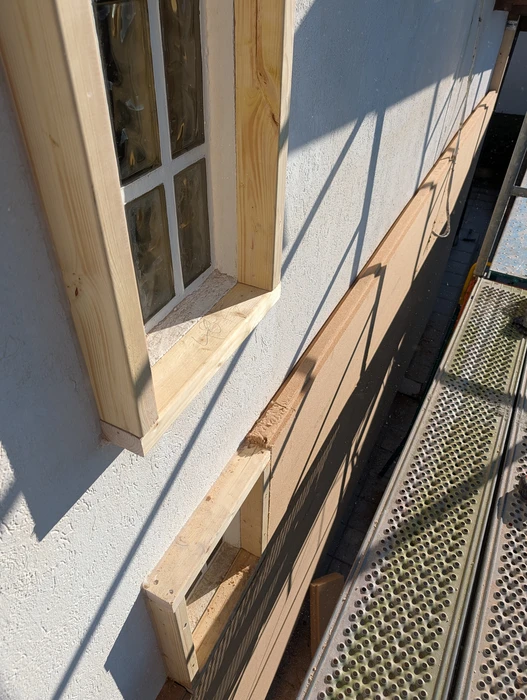 Atelier de menuiserie intérieur avec ouvrier travaillant sur structure bois